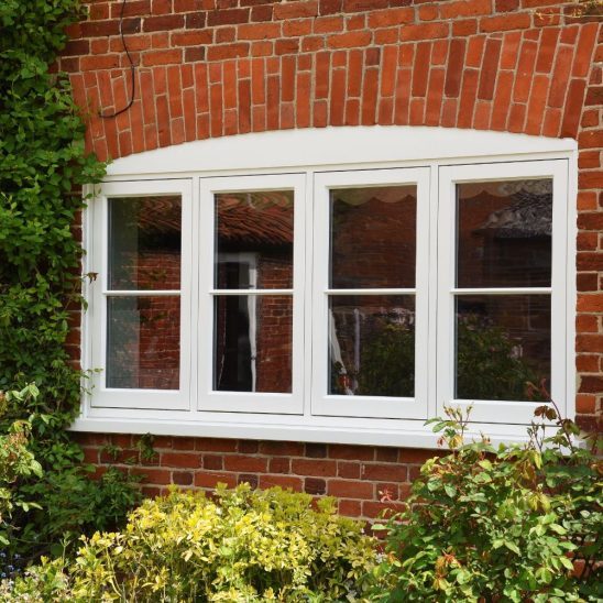 Wooden flush casement window in off-white with a single 18mm astragal bar in an arched design