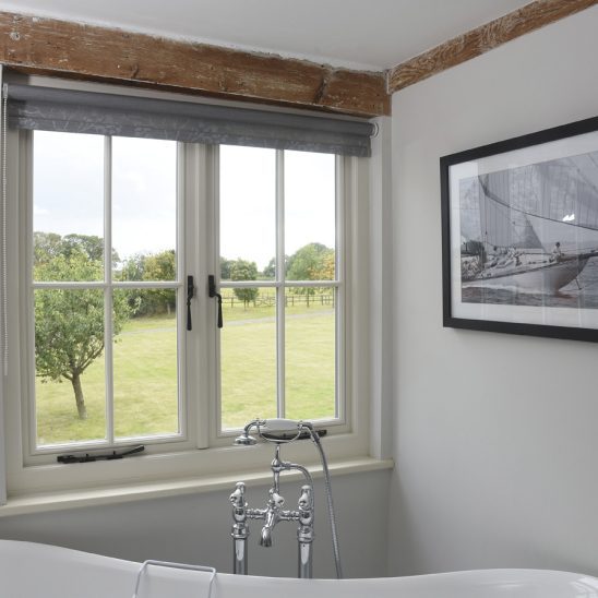 Timber casement windows with astragal bars and black handles and pegstays