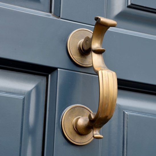 Doctors door knocker in antique brass on timber entrance door