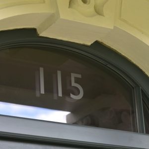 Arched fanlight with sandblasted house number over timber entrance door