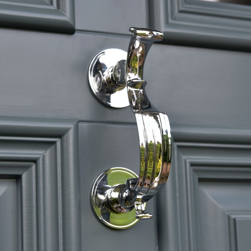 Polished chrome doctors door knocker on timber entrance door