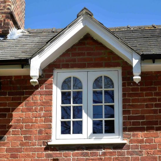 Cottage flush timber casement windows in off-white with 18mm astragal bars and true arch swept heads