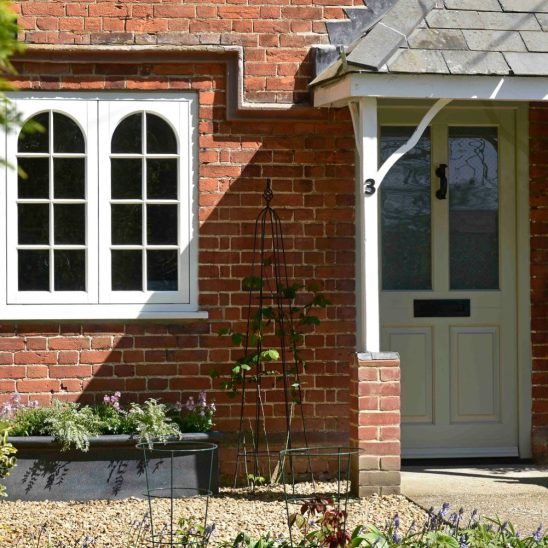 Kingston entrance door finished in French Grey with off-white timber casement windows
