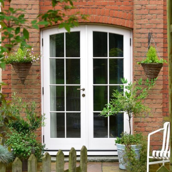 Timber arched French doors with Georgian bars in white