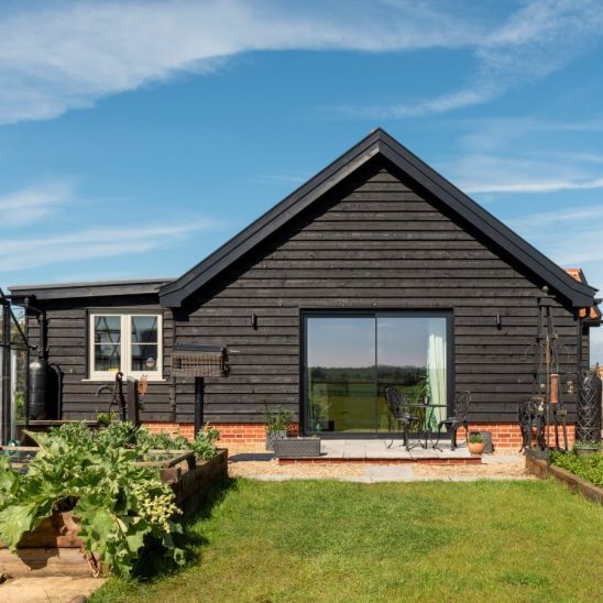 Timber clad annex with an aluminium sliding Sunflex patio door with super slim 20mm interlock maximising the view