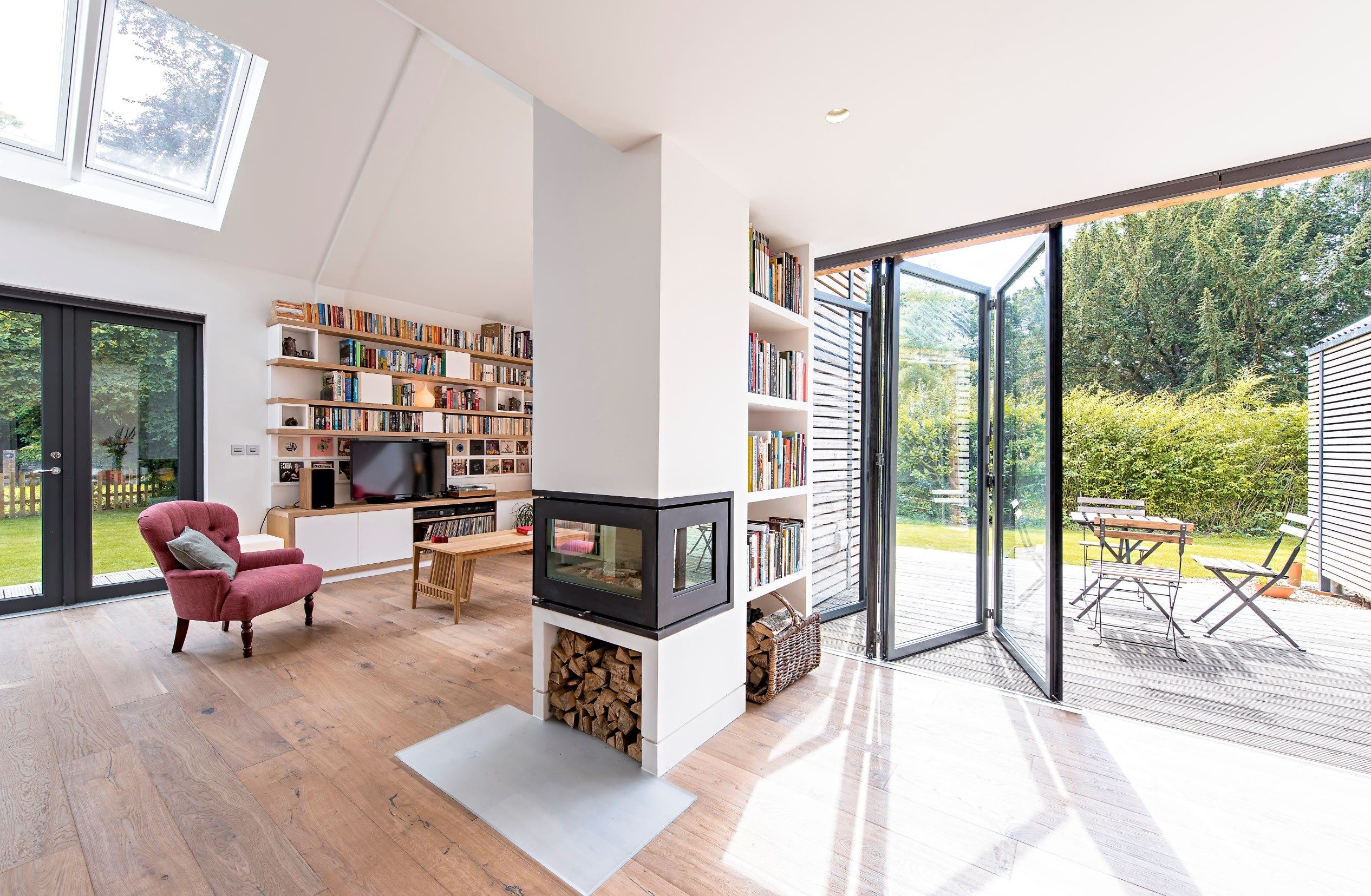 Partially open sunflex black bifold doors in a lounge settting