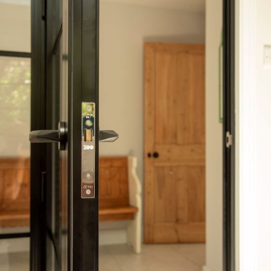 Aluco aluminium steel look internal glazed door with side panel, super slim 20mm glazing bars and Leon handle in matt Black