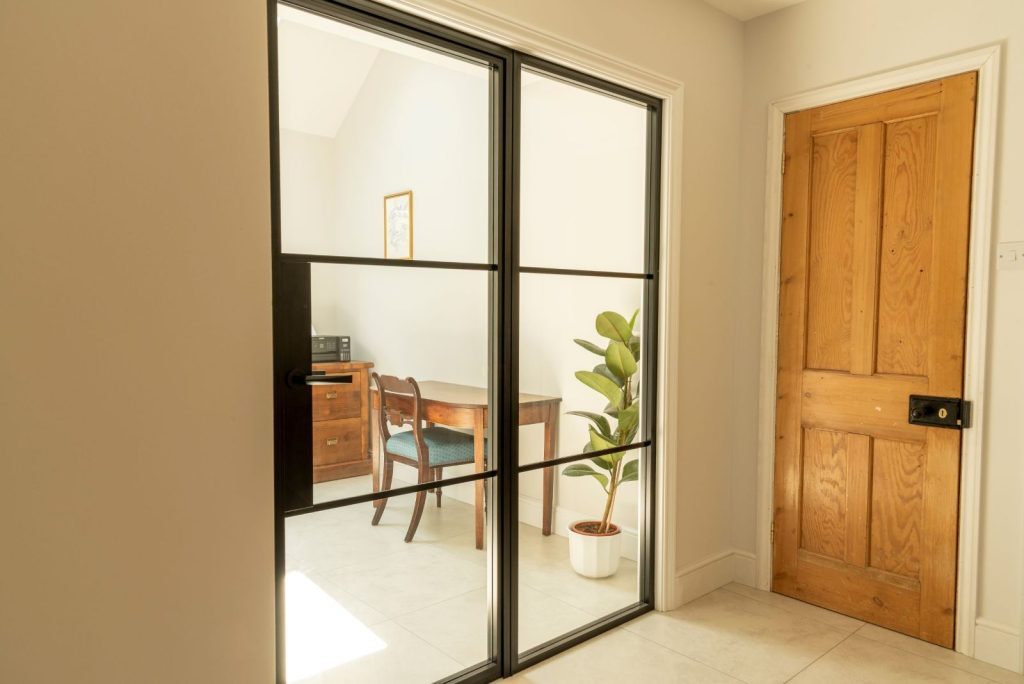 Aluco aluminium steel look internal glazed door with side panel, super slim 20mm glazing bars and Leon handle in matt Black