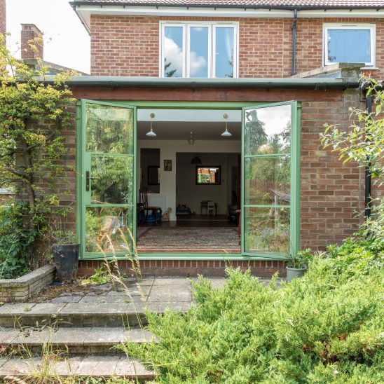 Green Aluco steel look French doors with side lights and super slim 20mm glazing bars.
