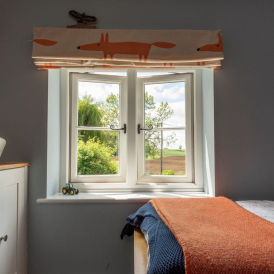 Evolution PVCu flush casement window with a single horizontal Georgian bar and black monkeytail handles. Olive Grey on the outside, white on the inside.