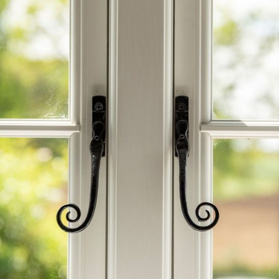 Evolution PVCu flush casement window with a single horizontal Georgian bar and black monkeytail handles. Olive Grey on the outside, white on the inside.