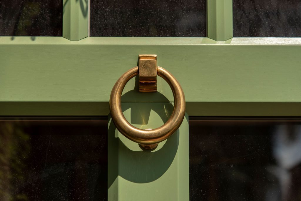 antique brass door knocker with period glazing bars and wood-effect profiles on Evolution front door. 