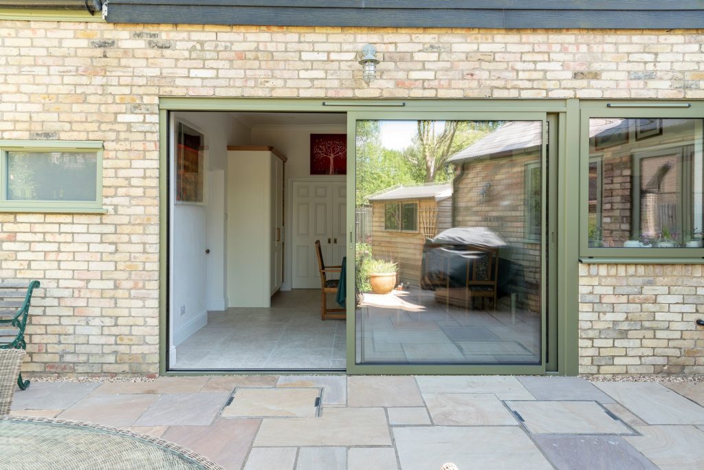 Sunflex SVG30 sliding doors with matching aluminium side window in green, with trickle vent and colour coded handle.