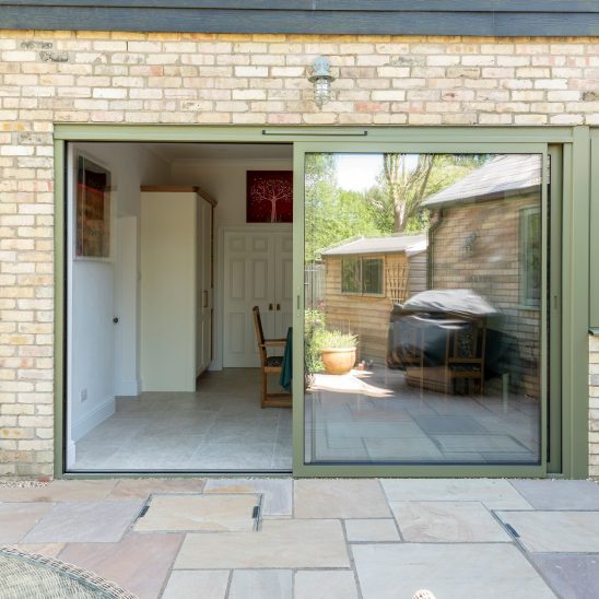Sunflex SVG30 sliding doors with matching aluminium side window in green, with trickle vent and colour coded handle.