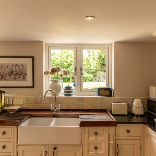 Evolution PVCu flush casement window with a single horizontal Georgian bar and black monkeytail handles. Olive Grey on the outside, white on the inside.