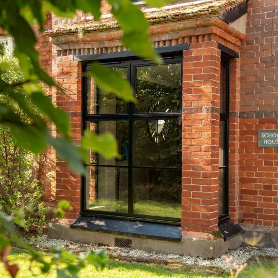 Red brick house with Art Deco black aluminium bay windows