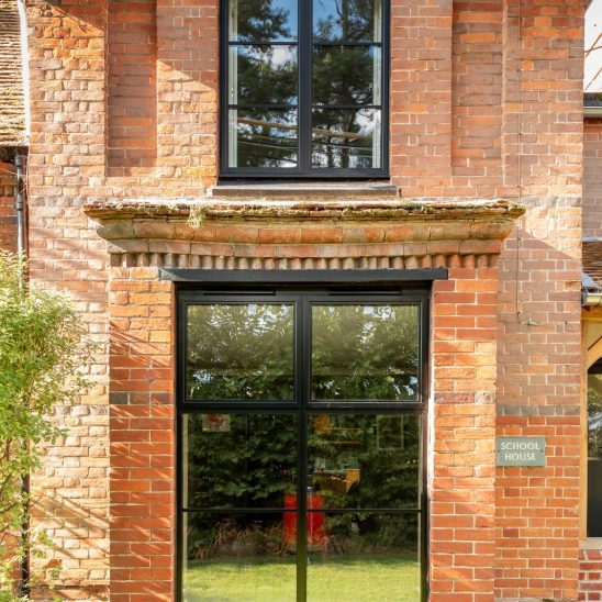 Red brick house with Art Deco black aluminium bay windows