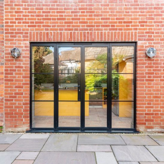 Black heritage, Art Deco aluminium patio doors with floating lock detail, slim glazing bars and side panels