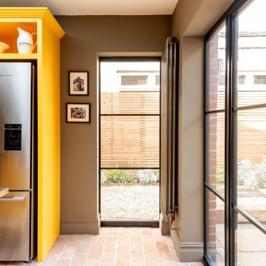 Contemporary kitchen with black aluminium heritage glazing and Patio doors featuring ultra slim glazing bars in Orford home