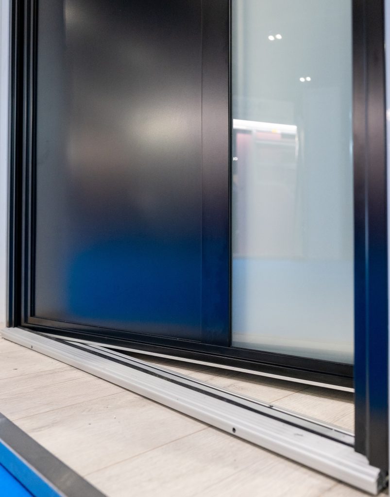 Partially open Aluco steel-look front door showing low accessibility threshold and steel style framing